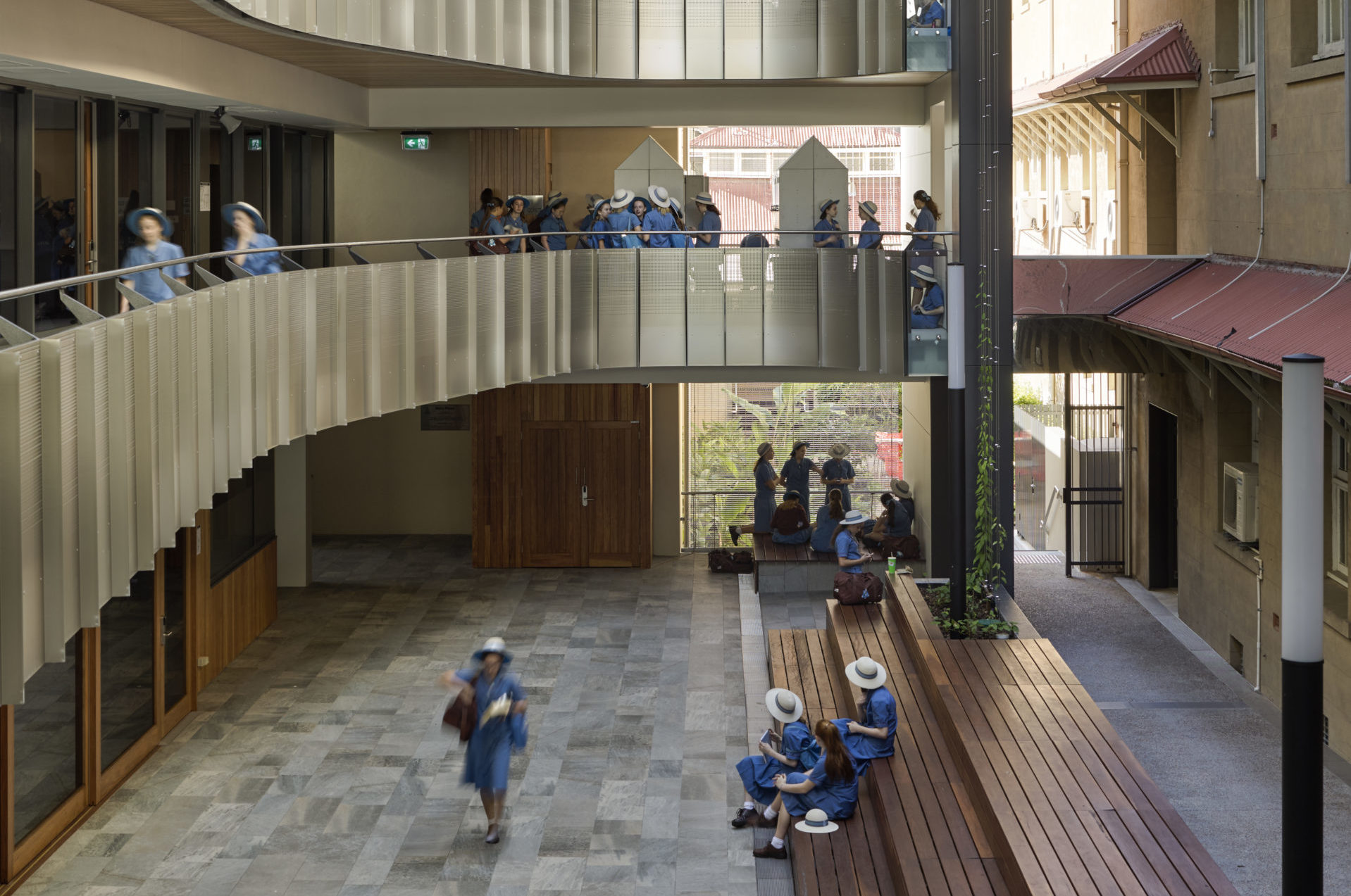 A photo of school students from All Hallows' School, walking around a multi-level school building.