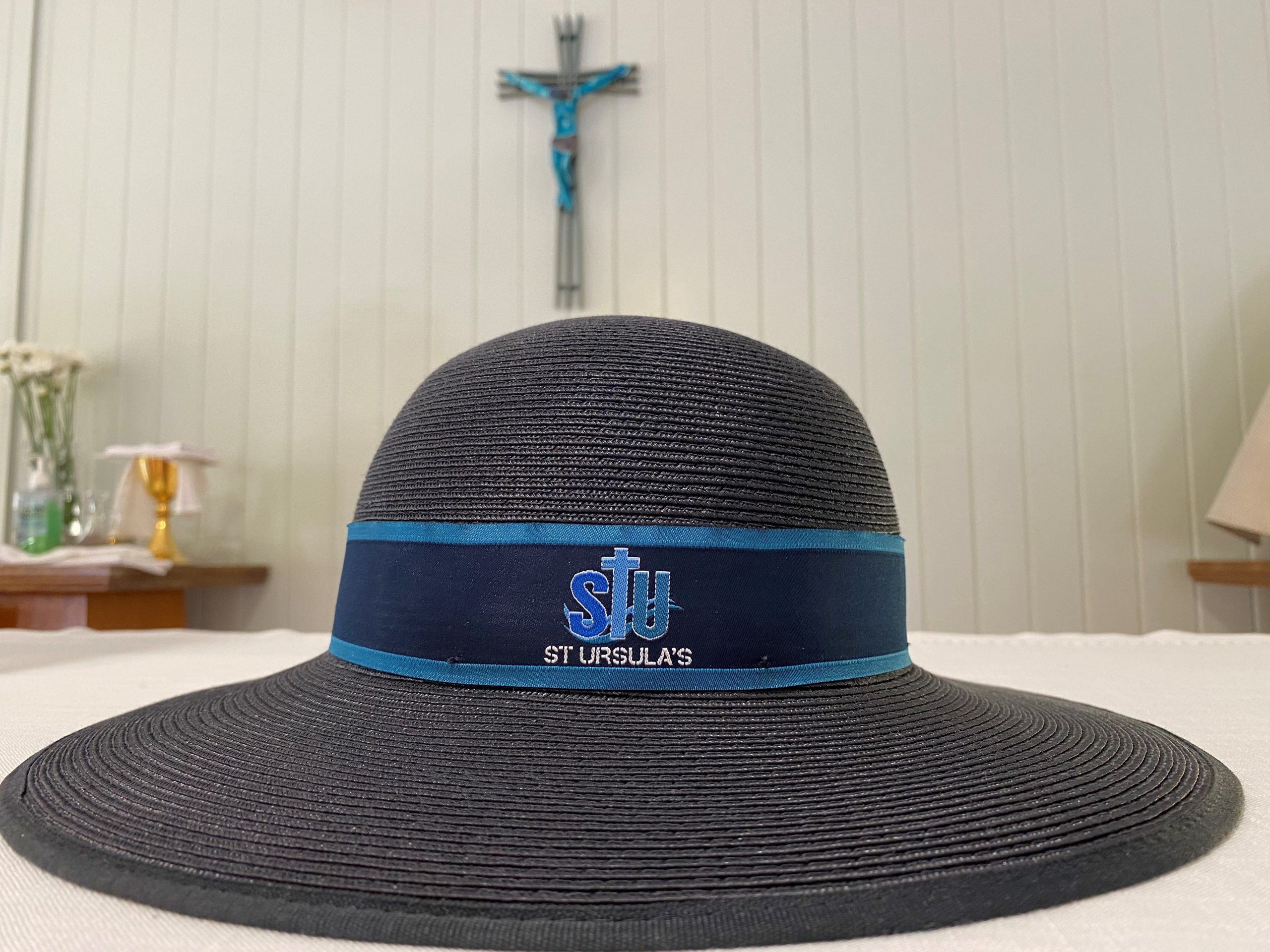 A photo of a St Ursula's College school hat placed on an altar.