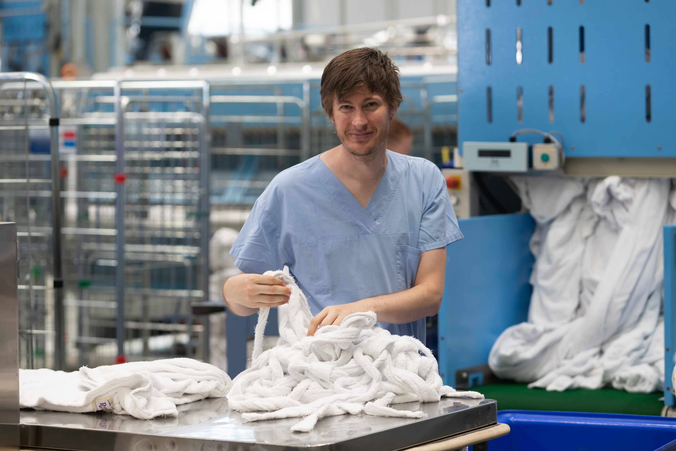 A photo of a Holy Cross Services team member working in their laundry.