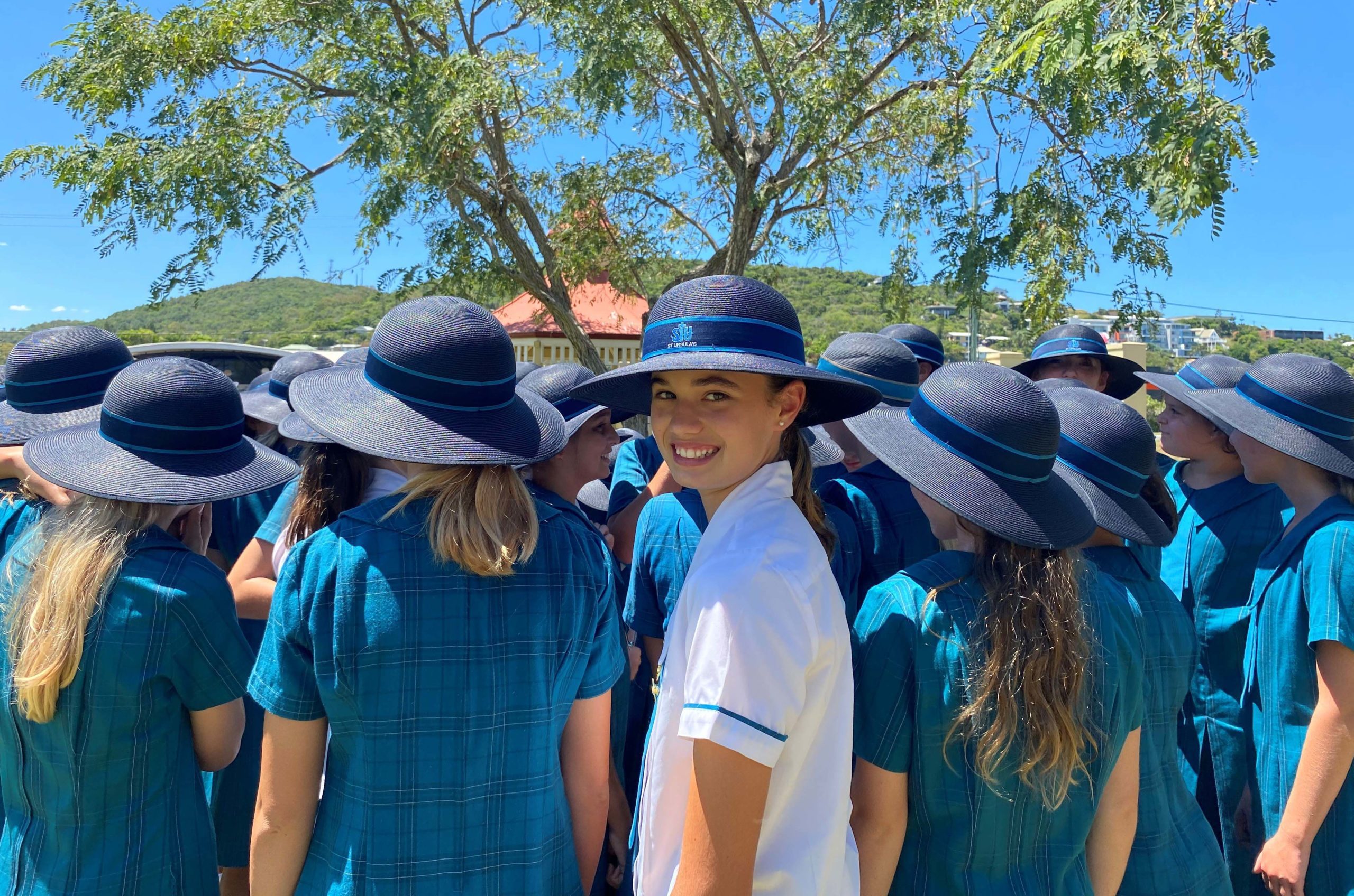 A photo of a group of St Ursula's College school students. One of the students is facing the camera and has a big smile on her face.