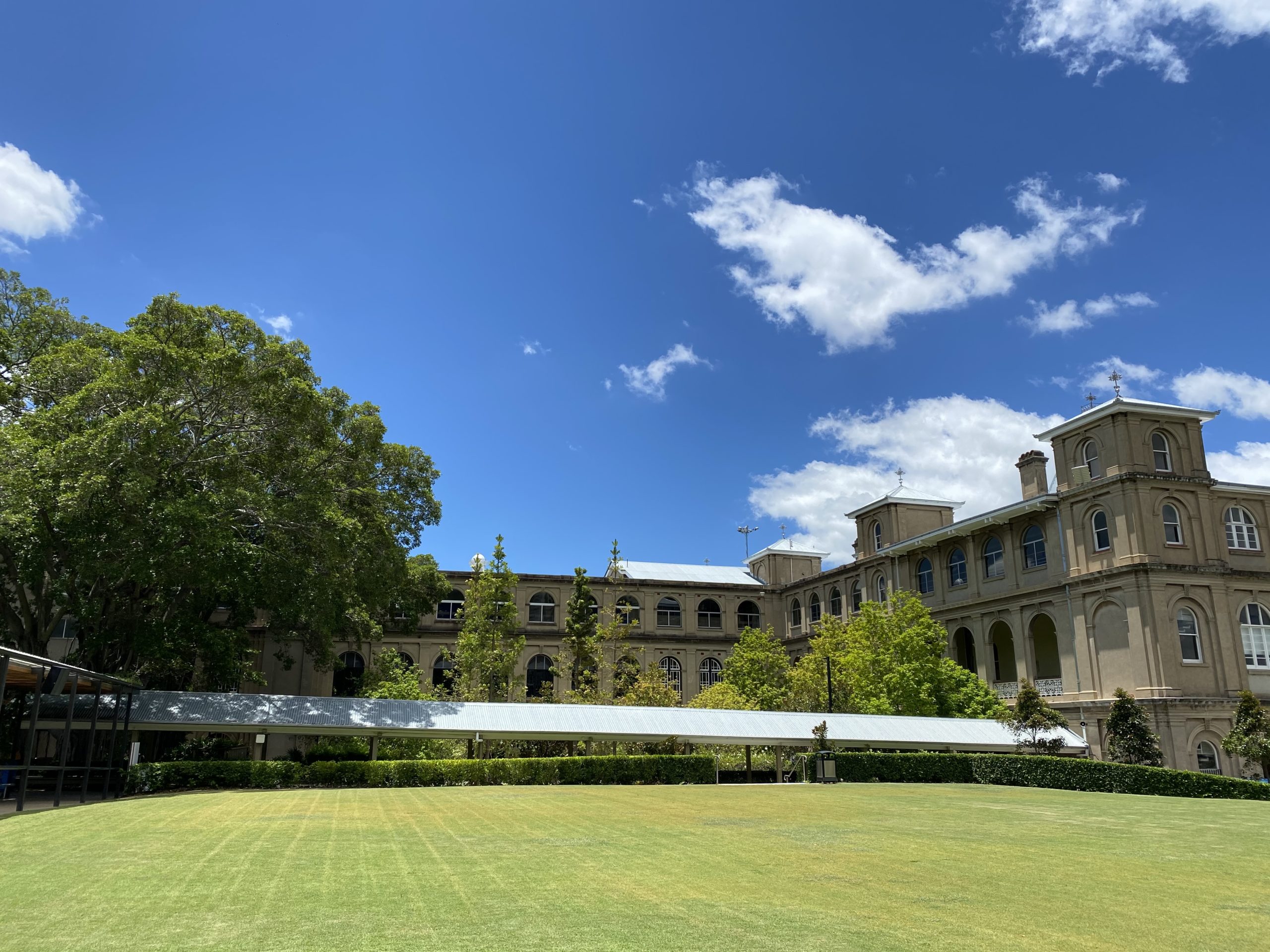 This is a photo of the school grounds of All Hallows' School. An original historic school building can be seen in the background.
