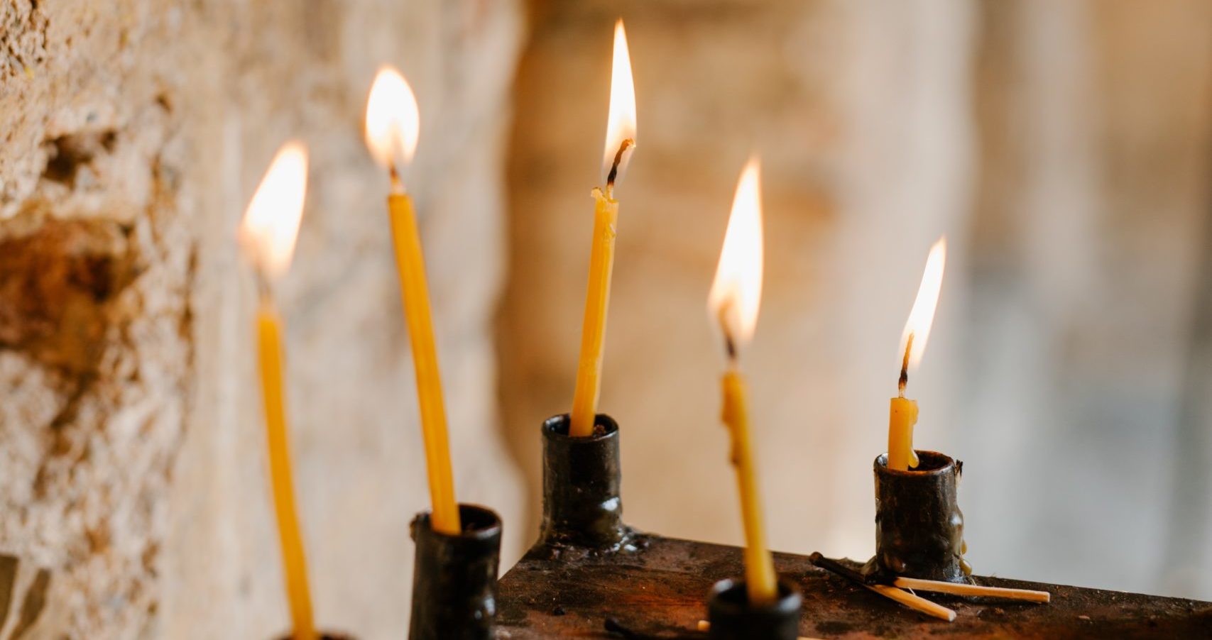 Lit candles in an old church.