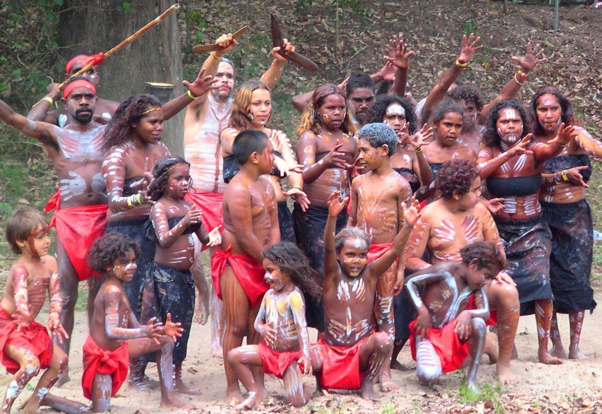 Aboriginal youth and children dancing. They are wearing traditional clothing and are adorned with body paint.