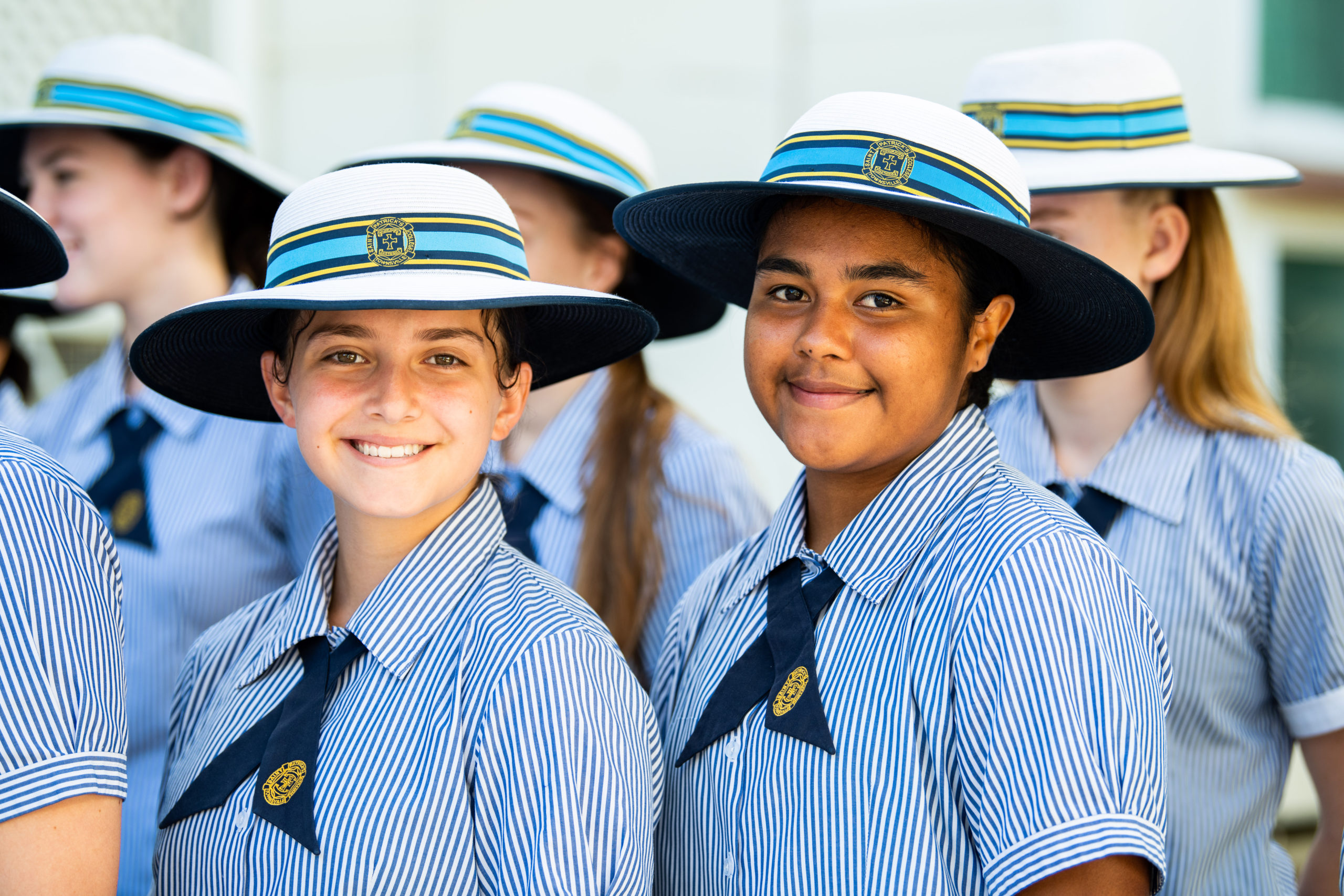 Two smiling students from St Patrick's College there are other students in the background.