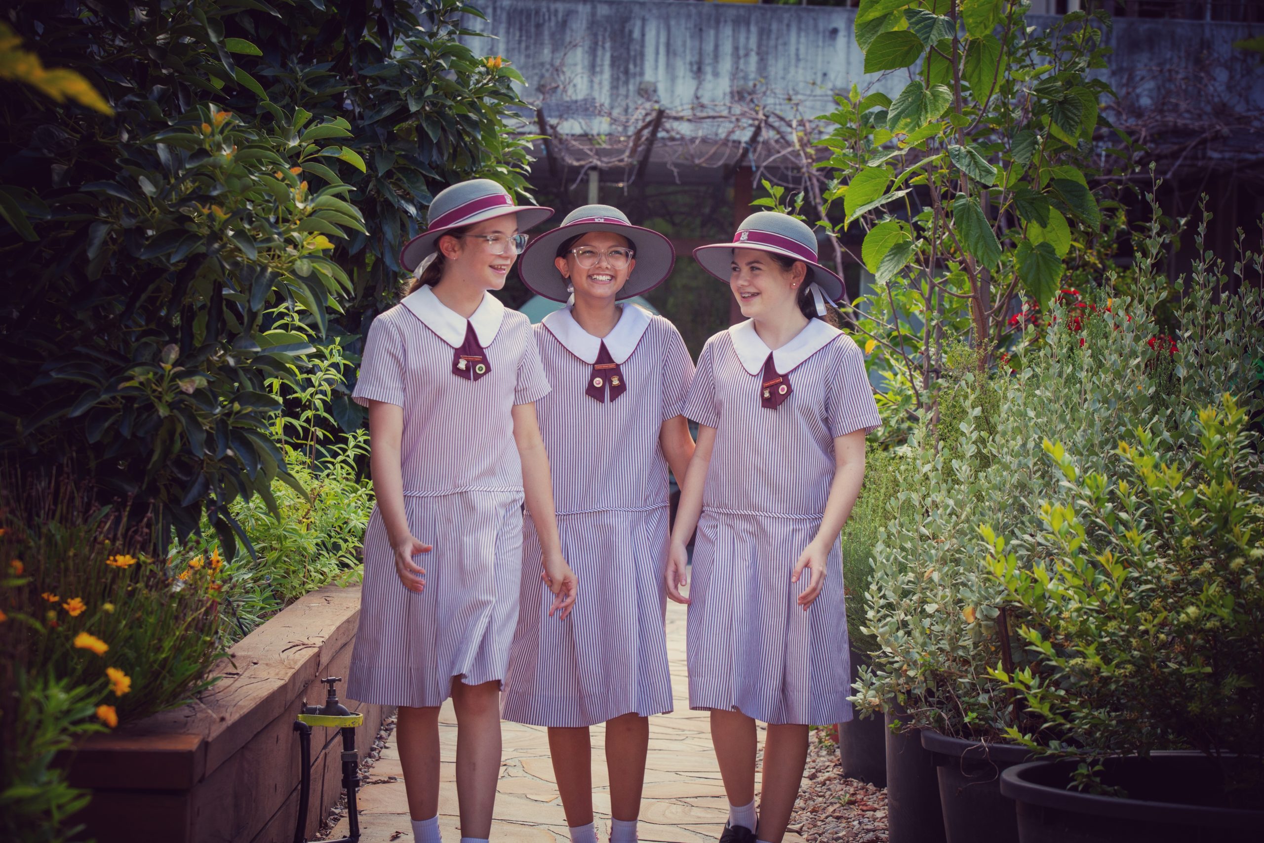 Three young students from Mount Alvernia College walking through the garden together.