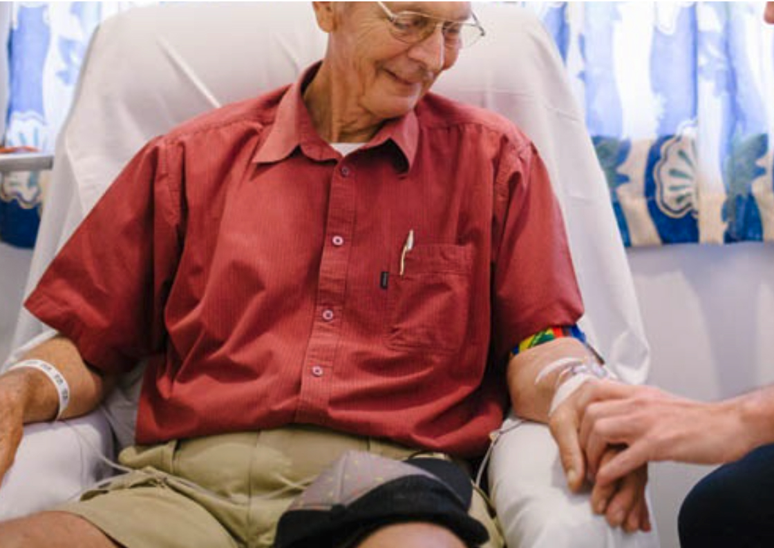 A photograph of an elderly man being cared for.