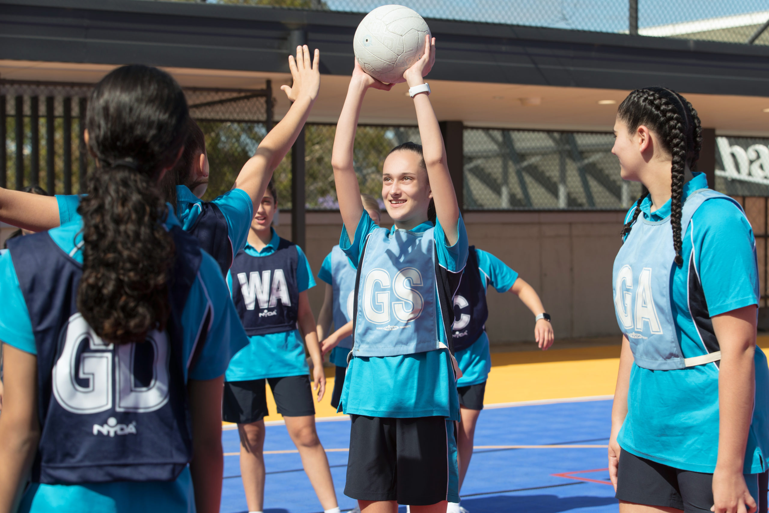 This is a photo of a group of Our Lady of Mercy College Parramatta students playing netball. The Goal Shooter is about to take her shot.