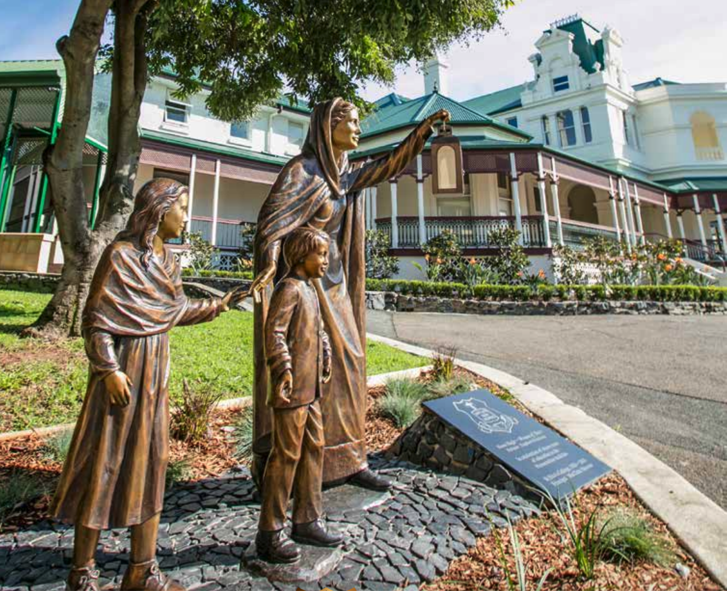 A statue located in the grounds of St Rita's College of Nano Nagle holding up her lantern with two children by her side.