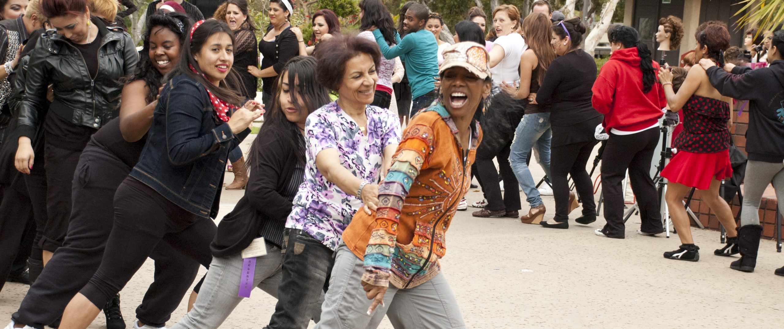 Group of about 25 people from different nationalities dancing in a conga line