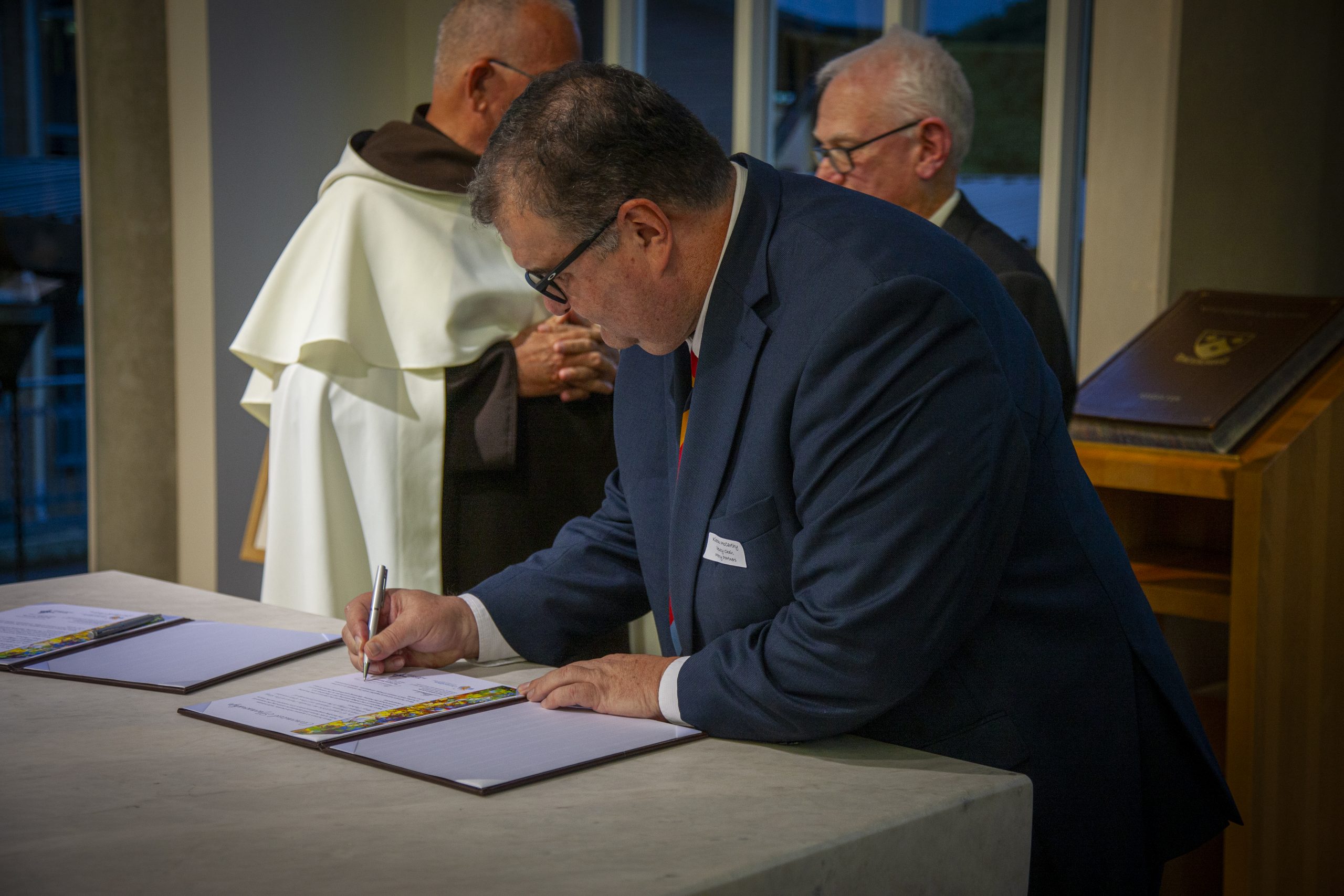 The signing of the Canonical Sponsorship certificate at the Whitefriars College transition ritual.